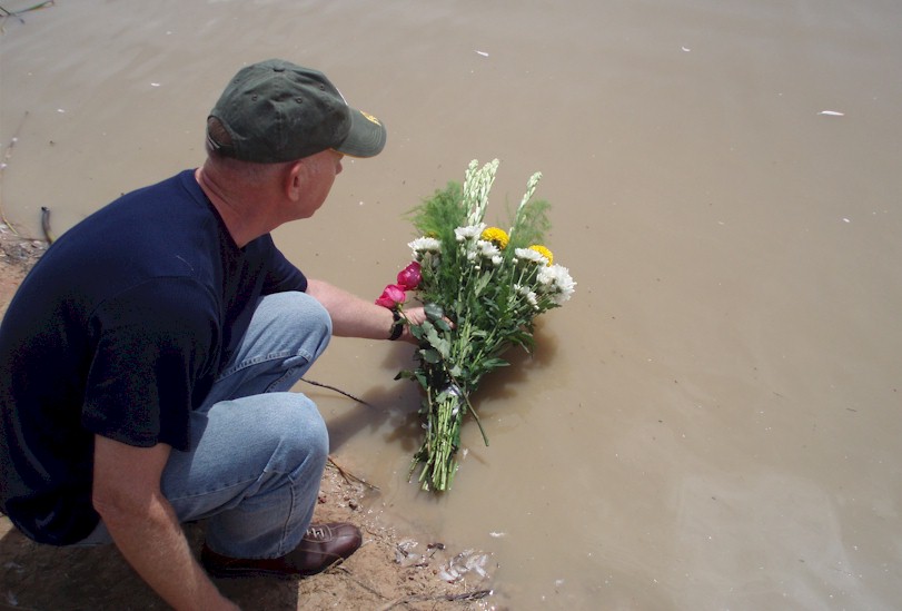 Placing flowers into the rice paddy at the bottom of the dike where Carl died on May 16, 1968.  The authorities would not allow a photo up on top of the dike.  The Cambodian border is just 100 yards away.